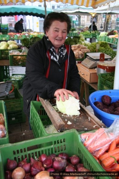 Bäuerin reibt Weisskohl am Markt