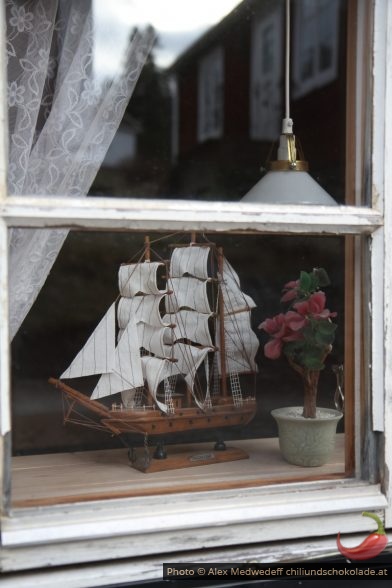 Bateau miniature derrière une fenêtre de Norrfällsviken