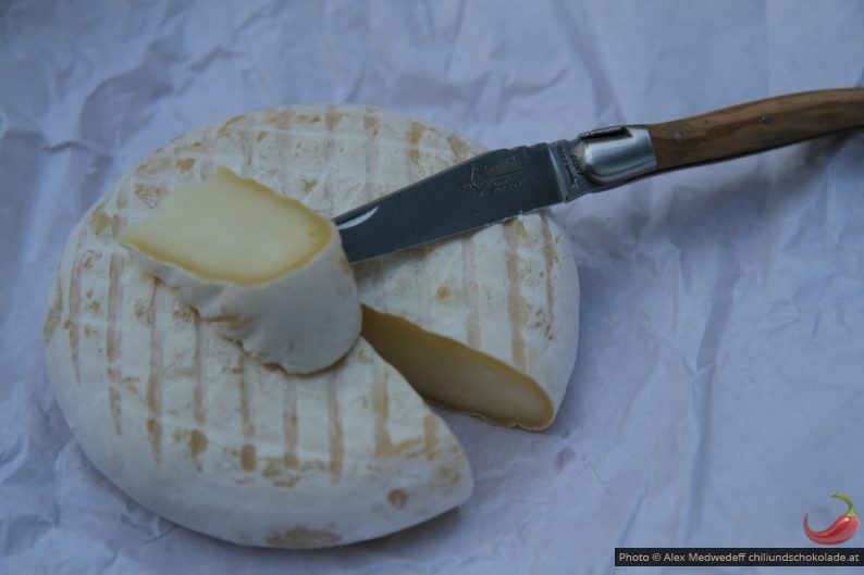 Couteau Laguiole et un fromage mi-dur fraîchement coupé