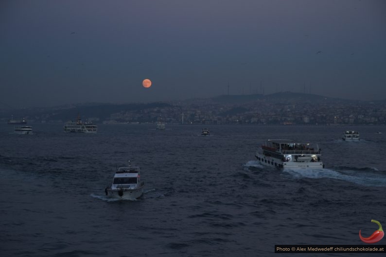 Fährschiffe am Bosporus vor aufgehendem Mond